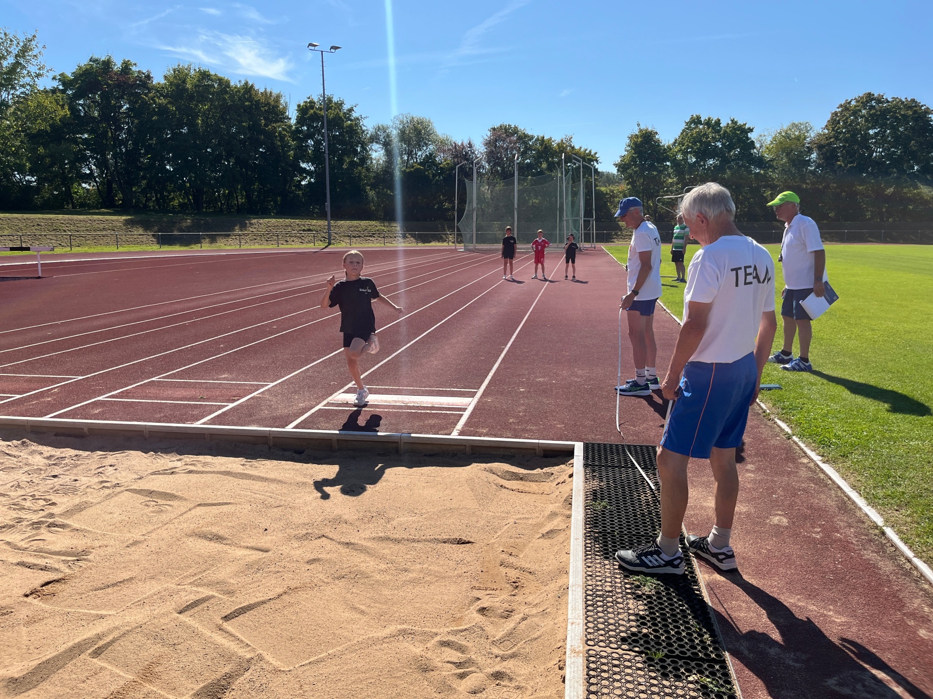 Long jump acceptance at the 2025 sports festival An examiner scrutinises a girl's long jump.