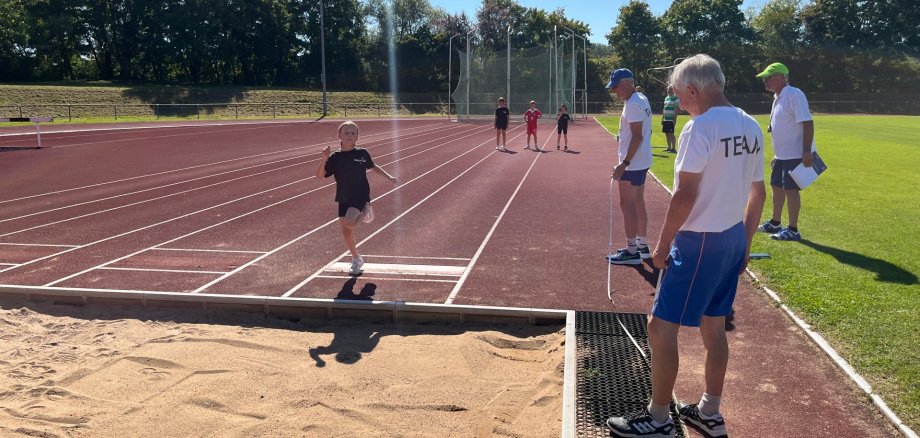 Long jump acceptance at the 2025 sports festival An examiner scrutinises a girl's long jump.