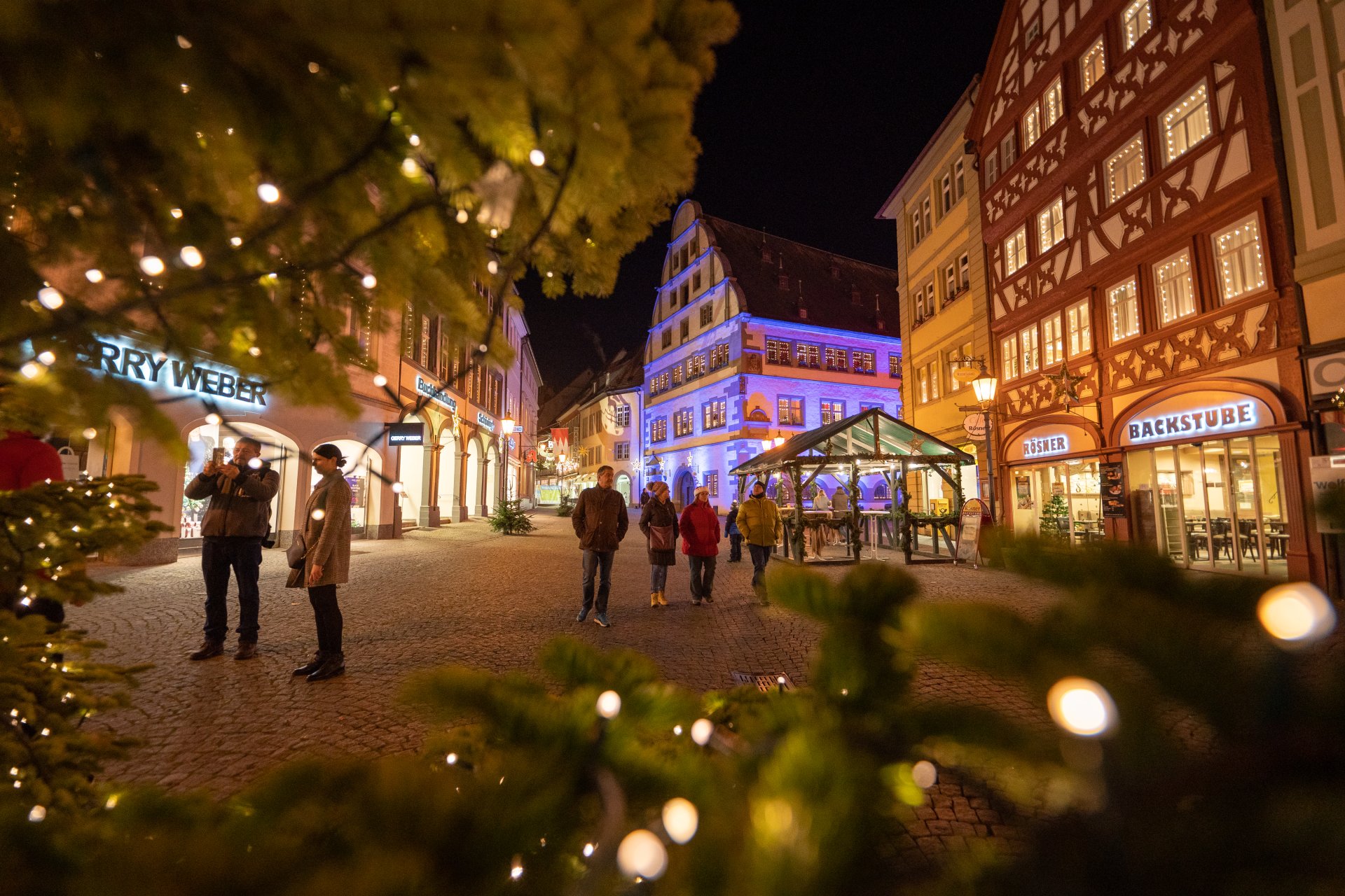 A festive meeting place The market square is lit up with lights. Stalls are selling mulled wine and a variety of food.
