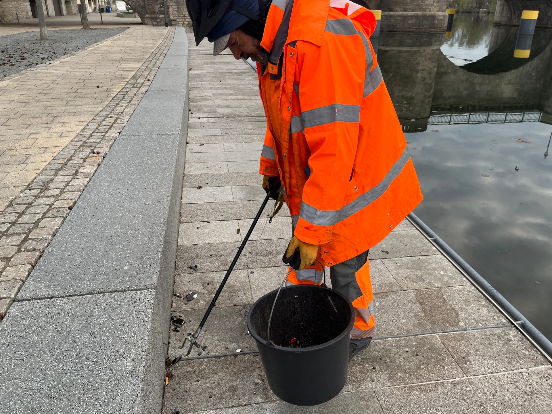 Stadtreiniger am Mainkai Stadtreiniger sammelt Müll am Mainkai vom Boden auf.
