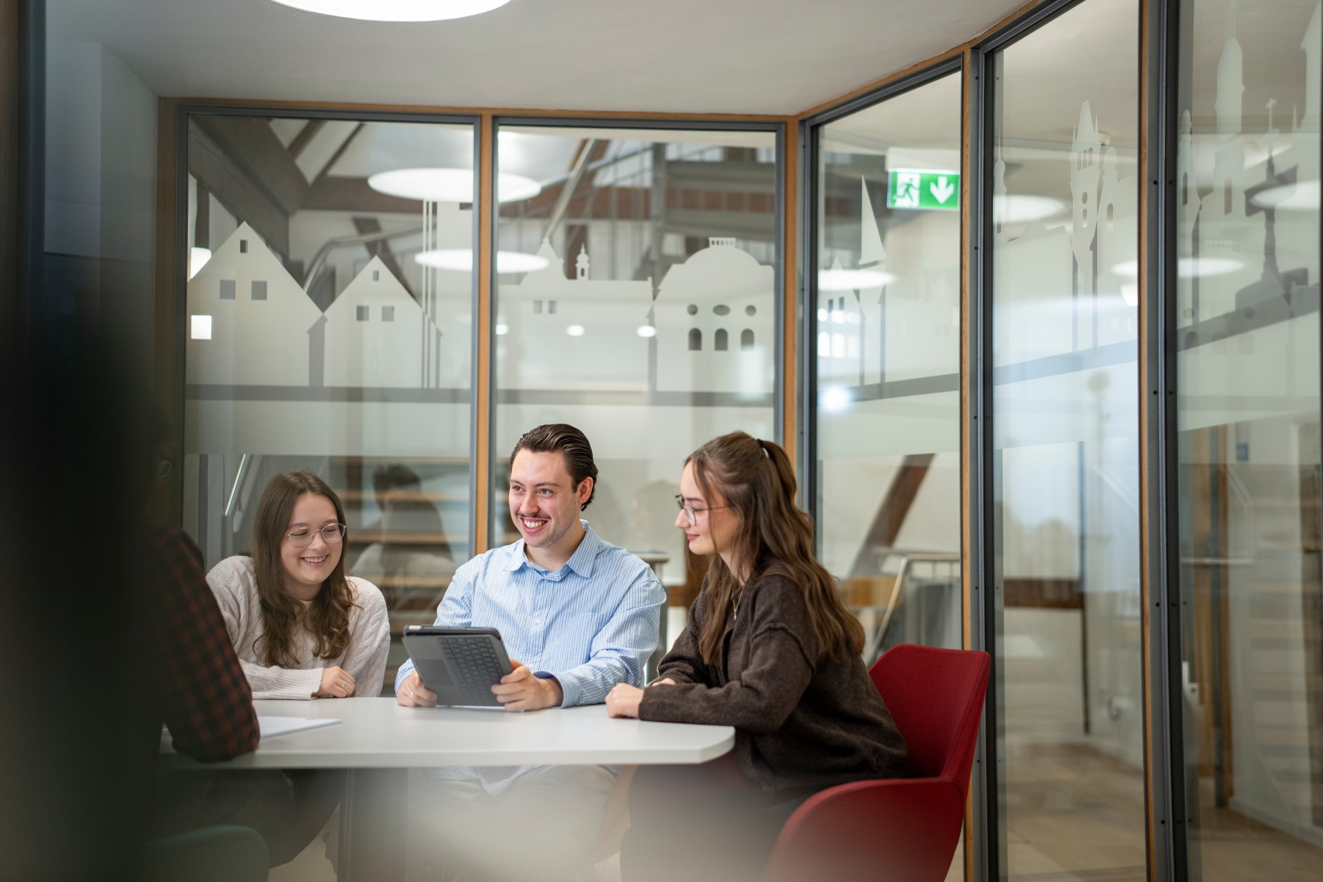 Four employees sit together at a meeting table and exchange ideas.