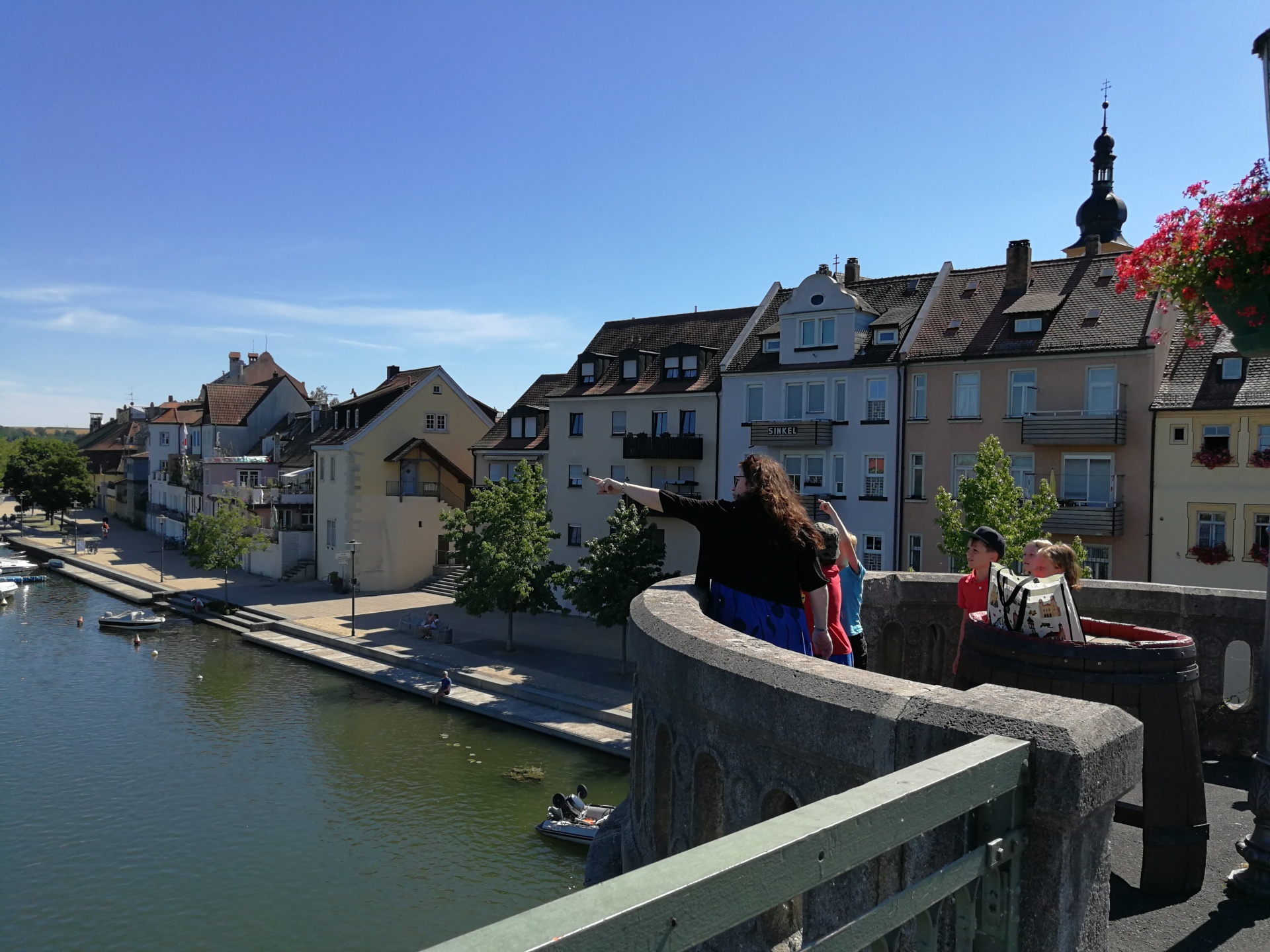 A tour guide explains something to children on the old Main Bridge