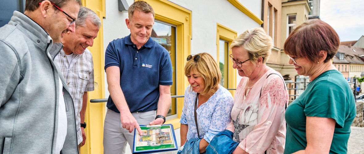 Kitzingen guided tour A man shows the group a picture and explains something about it