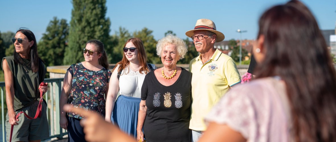 Guided tour of Kitzingen for groups A tour guide is with her group on the old Main bridge