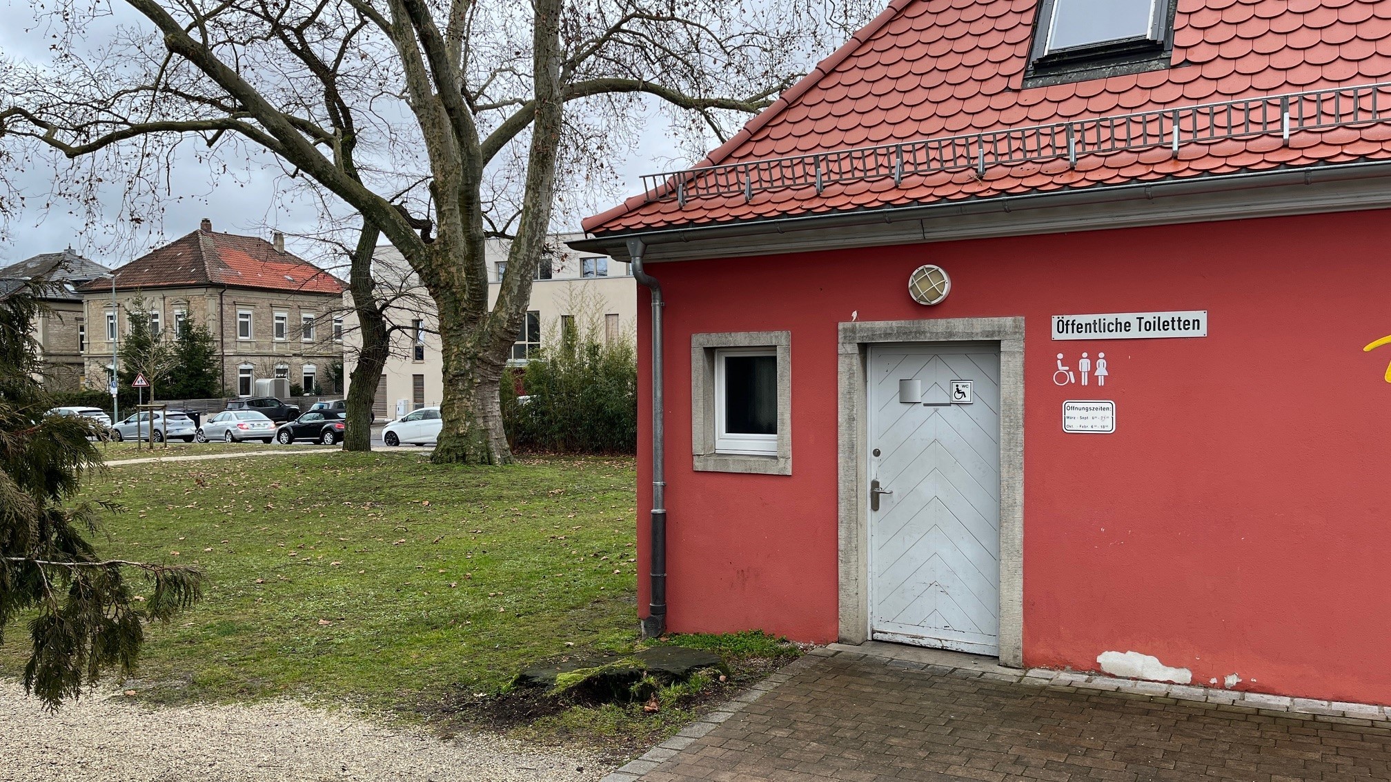 Public WC Rosengarten Exterior view of the public toilet in the rose garden. Signs next to the white door indicate the toilet.